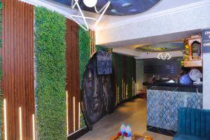 a green wall in a restaurant with a bar at Hotel White House in Navi Mumbai