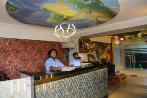 two men sitting at a bar in a restaurant at Hotel White House in Navi Mumbai