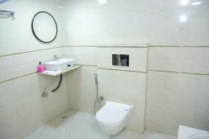 a bathroom with a toilet and a sink and a mirror at Hotel White House in Navi Mumbai +111 photos