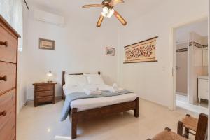 a bedroom with a bed with a ceiling fan at Citron, Parga Center Residence in Parga