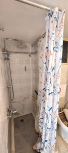 a bathroom with a shower with a shower curtain at Diamond apartments in Artemida +35 photos