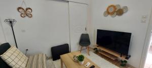 a living room with a couch and a television at Diamond apartments in Artemida