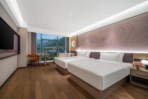 a hotel room with two beds and a flat screen tv at Maison New Century Ninghai Railway Station in Ninghai +78 photos