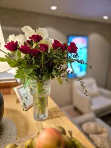 a vase filled with red and white flowers on a table at Hotell Rådhuset in Lidköping