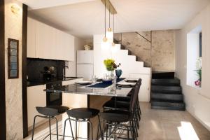 a kitchen with a bar with stools and a staircase at Parenthèse Enchantée – Proche Disney in Collégien