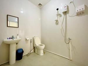 a bathroom with a toilet and a sink at Arriyus Apartelle in Maya
