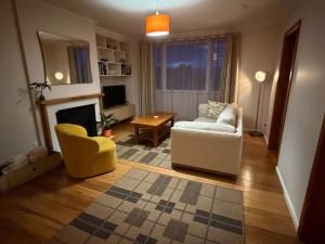 a living room with a couch and a chair at Tyne above Town in Oamaru