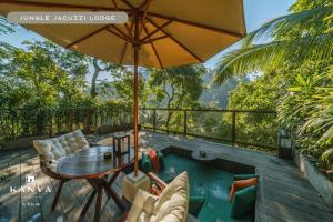 a patio with a table and chairs and an umbrella at Kanva Ubud in Tegalalang