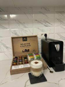a cup of coffee next to a box of muffins at Acasa Concept in Arad