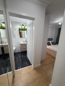 a bathroom with a mirror and a bedroom with a bed at Acasa Concept in Arad +8 photos