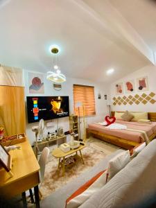 a living room with two beds and a tv at Olango Island - S&E-2 Tiny Guest House Fully Furnished with Hot Shower, Washer, Wi-Fi, Netflix & King-size Bed in Lapu Lapu City