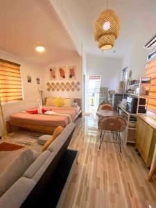 a bedroom with two beds and a couch in it at Olango Island - S&E-2 Tiny Guest House Fully Furnished with Hot Shower, Washer, Wi-Fi, Netflix & King-size Bed in Lapu Lapu City