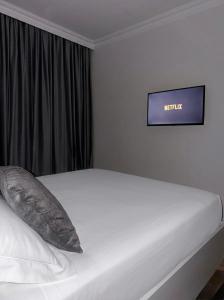 a white bed in a room with a sign on the wall at Acasa Concept in Arad