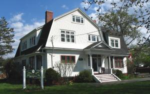 a white house with a sign in front of it at Belgravia B&B in Truro