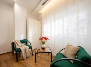 a living room with a green couch and two chairs and a table at Bengasi Central Loft in Stazione Bari Centrale