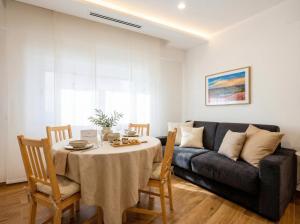 a living room with a table and a couch at Bengasi Central Loft in Stazione Bari Centrale +10 photos