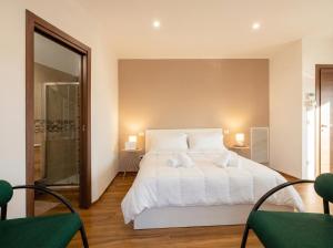 a bedroom with a large white bed and two chairs at Bengasi Central Loft in Stazione Bari Centrale