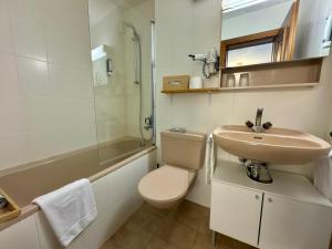 a bathroom with a sink and a toilet and a shower at Ferienwohnungen Hotel Bellevue in Seelisberg +33 photos
