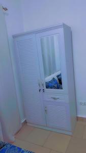a white cabinet with a glass door in a room at A & A Apartments in Serekunda +2 photos
