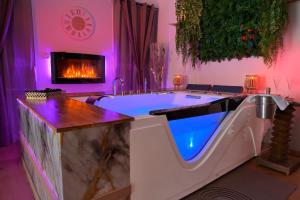 a large bathroom with a tub with a fireplace at Echappée Nocturne in Saint-Privat