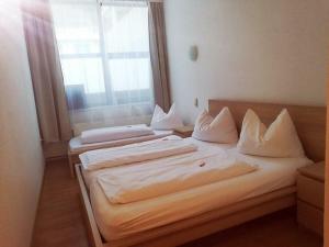 two twin beds in a room with a window at Econnomy Adler in Golling an der Salzach