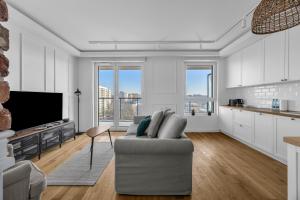 a living room with a couch and a kitchen at Mehoffera Superior Apartment by BookingHost in Warsaw