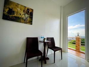 a table and two chairs in a room with a window at Arriyus Apartelle in Maya