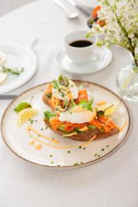 a plate of food on a table with a cup of coffee at Hotel Jelgava in Jelgava +69 photos