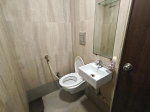a bathroom with a white toilet and a sink at Hotel Silver Shine Jogeshwari in Mumbai