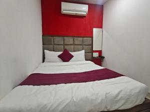a bedroom with a large bed with a red wall at Hotel Silver Shine Jogeshwari in Mumbai