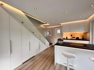 a large kitchen with white cabinets and a staircase at Hotel LandGut & Residenz DRIEHOF in Tecklenburg