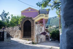 a pink building with a gate and a stone wall at Citron, Parga Center Residence in Parga