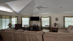 a living room with a couch and a ceiling fan at Bayside Home With 4 Bedrooms And Elevator in North Beach Haven