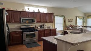 a kitchen with wooden cabinets and a stove top oven at Bayside Home With 4 Bedrooms And Elevator in North Beach Haven