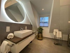 a bathroom with a sink and a mirror at Hotel LandGut & Residenz DRIEHOF in Tecklenburg +82 photos