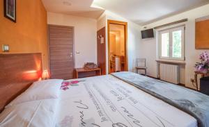 a bedroom with a large bed with writing on it at Agriturismo La Part in San Zeno di Montagna
