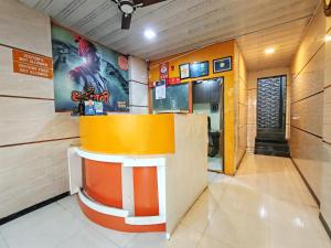 a fast food restaurant with a yellow and orange counter at Hotel Orange Inn in Koparpāda