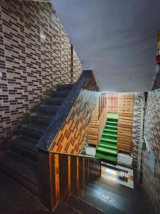 a set of stairs with a green floor and a brick wall at Hotel Orange Inn in Koparpāda