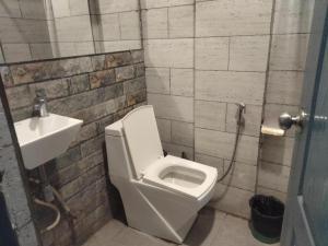 a bathroom with a white toilet and a sink at Hotel MM Inn in Rishīkesh +11 photos