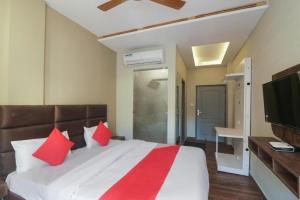 a bedroom with a large bed with red pillows at Hotel MM Inn in Rishīkesh