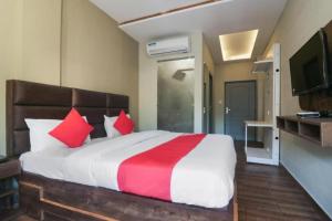 a bedroom with a large bed with red and white pillows at Hotel MM Inn in Rishīkesh