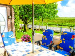 a table and two chairs with an umbrella on a porch at Pension Feuerschiff in Borkum
