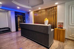 a lobby with a counter with a vase on it at Hotel Mariott Inn in Prayagraj +11 photos