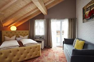 a bedroom with a bed and a couch at Vintage Hotel Charivari- Sommer Hörnerbahnen kostenlos mit Restaurant in Bolsterlang