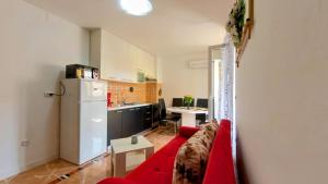 a living room with a red couch and a kitchen at Apartmani Daria in Medulin