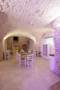 a dining room with a table and white chairs at Accogliente Dimora in Putignano +60 photos