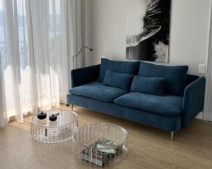 a blue couch in a living room with two tables at Hotel Eden Palace au Lac in Montreux