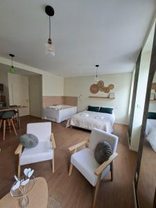 a bedroom with a bed and chairs and a table at Le Ségusiave SPA in Feurs