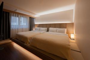 a bedroom with a large bed with white pillows at Mandeok Denbasta Ryokan in Busan +147 photos