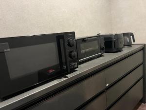 a counter with two microwaves and a microwave on it at Anbo-ing in Yakushima